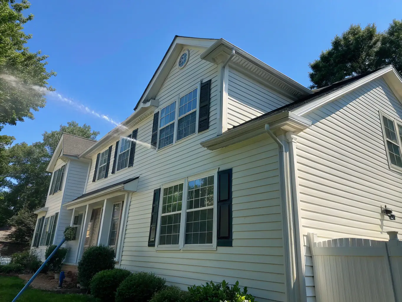A residential house with clean siding after a power washing service, showcasing the effectiveness of house washing.